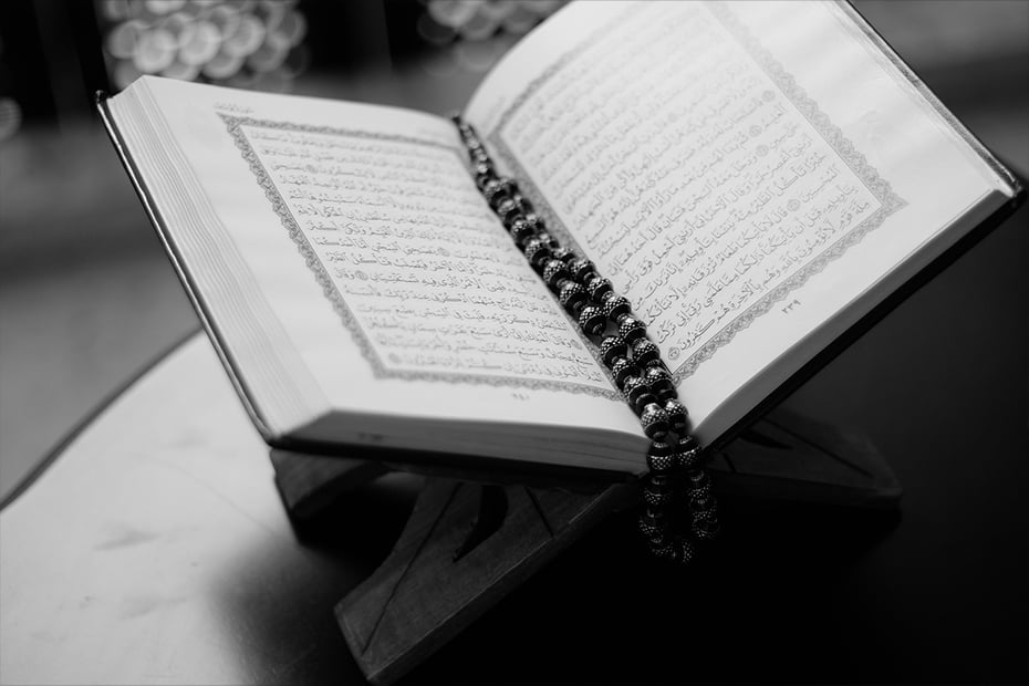 Bilde av en oppslått koran med et bønnekjede liggende midt i.